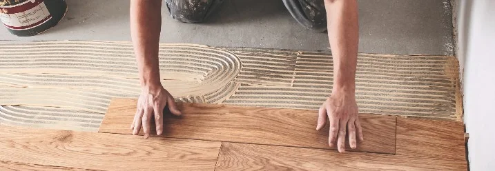 Person verlegt Holzdielen